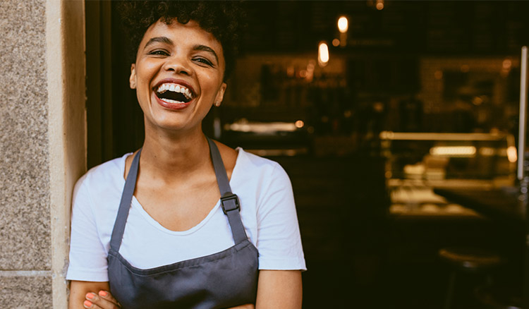 African American Woman Smiling In Shop Doorway