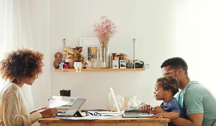 Family Of Three Working At Table