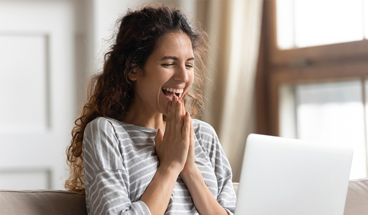 Women smiling while looking at laptop